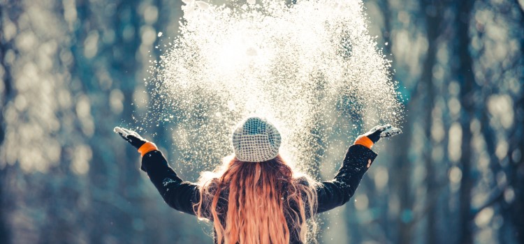 tjej kastar upp snö i luften